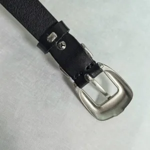 Detail view of black leather belt with vintage silver pin buckle accessory, sturdy zinc alloy construction.