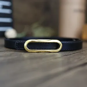 Minimalist black leather belt for women featuring elegant gold oval buckle close-up view.