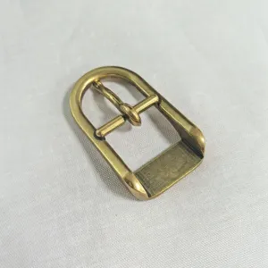 Detailed view of golden zinc alloy half-round pin buckle, vintage metallic texture for bags.