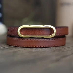 Brown leather detail shot showcasing fine stitching texture and glossy gold-tone metal buckle.