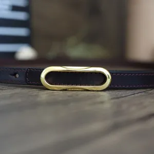 Close-up details of women genuine leather belt featuring a stylish golden oval buckle.