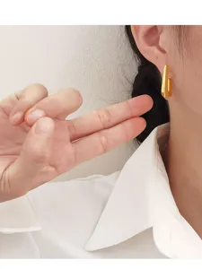 Detailopname van een moderne minimalistische gouden geometrische earcuff gedragen door model
