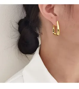Gedetailleerde close-up van minimalistische gouden geometrische oorbellen voor dames