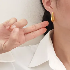 Minimalistische gouden geometrische oormanchet oorbellen gedragen door een model