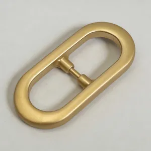 Close-up of a sleek gold oval metal belt buckle, smooth matte finish for women's waistbands.