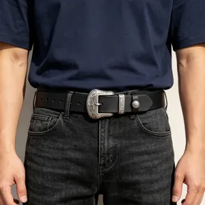 Detailed shot of men's genuine leather belt with vintage engraved silver buckle for jeans.