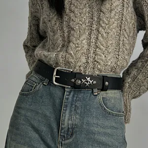 Close-up detail view of black leather belt with vintage silver cross metal hardware.