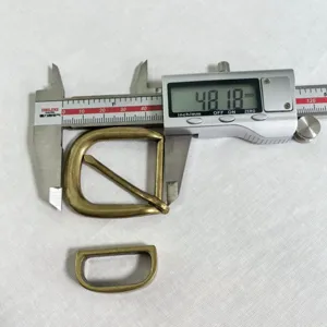 Retro antique brass D-ring belt buckle detail showing precise measurement with caliper.