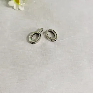 Primo piano di una doppia fibbia ovale in metallo argentato, accessorio compatto.