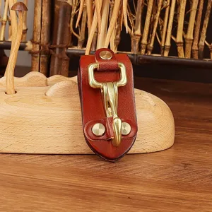 Leather belt key holder detail, durable brass hook and snap fastener for waist accessories.