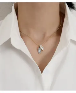 Elegant gold necklace with two overlapping white and grey enamel leaf pendants on model.