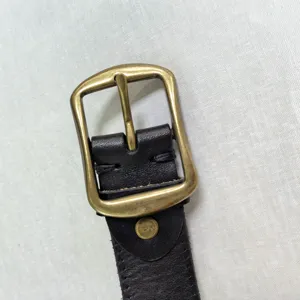 Primo piano del dettaglio della fibbia per cintura in lega di zinco vintage e pelle.