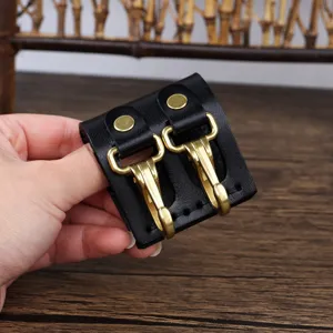 Close up detail of black leather belt keychain loop featuring durable dual brass hooks accessories.