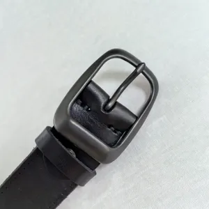 Dettaglio fibbia per cintura uomo, pelle nera liscia, accessorio di ferramenta durevole.