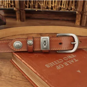 Detailed close-up of brown leather belt featuring vintage metal decorative buckles and sturdy pin buckle.