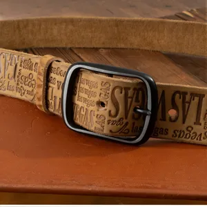 Close-up detail of vintage brown leather belt with black metal buckle and embossed letters.