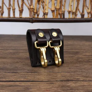 Close-up detail of genuine leather key belt loop with brass hooks, sturdy hardware accessory.