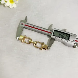Vista dettagliata del connettore di fibbia in metallo dorato a forma di U per abbigliamento.