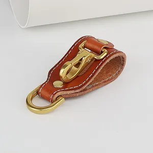 Close-up detail of brown genuine leather belt key holder showing durable brass clasp hardware.