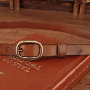 Close-up detail of women vintage genuine leather belt with retro bronze oval buckle.