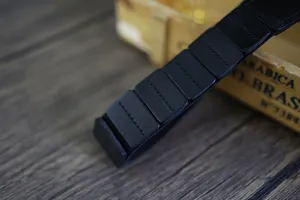 Detailaufnahme eines schwarzen, segmentierten Leder-Taillengürtels, ideal für Kleider und Mäntel.