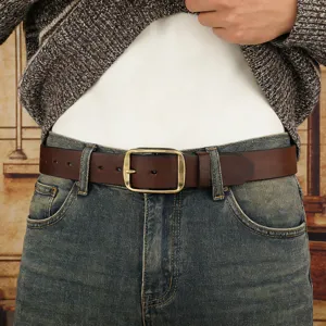 Detail view of a retro brown leather belt with metal pin buckle worn with jeans.