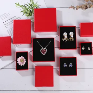 Collection de boîtes à bijoux rouges avec inserts noirs présentant des ornements