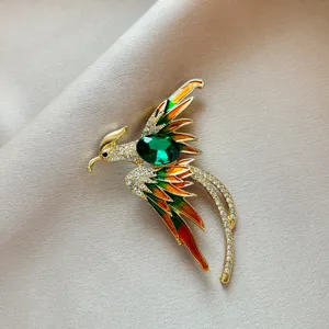Detailed close-up of a vintage crystal phoenix brooch featuring rhinestones and enamel.