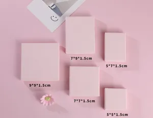 Collection de boîtes à bijoux roses de différentes tailles pour bagues et boucles d'oreilles.
