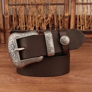 Vintage brown leather belt featuring an intricate carved silver metal buckle and concho detail.