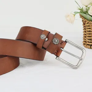 Detailed view of a handmade leather belt in vintage brown with silver buckle and floral rivets.