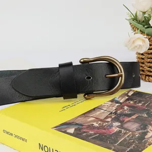 Close-up of a classic black genuine leather belt with a vintage brass horseshoe buckle.
