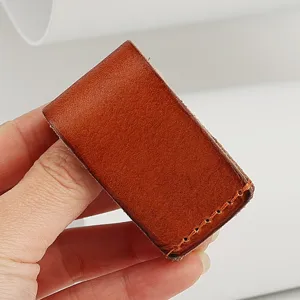 Handmade leather belt loop detail, genuine cowhide brown key holder attachment, close-up view.