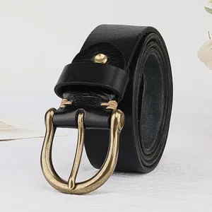 Close-up of men's genuine leather belt with antique brass horseshoe buckle, rolled neatly.