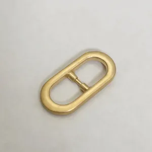Metal oval slider buckle detail view, premium gold tone hardware for bags and belts, close up.