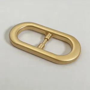Golden oval metal belt buckle detail, classic hardware accessory for women waistband or bag straps.
