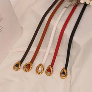 Detailed view of thin leather belts with irregular gold metal teardrop buckles in various colors.