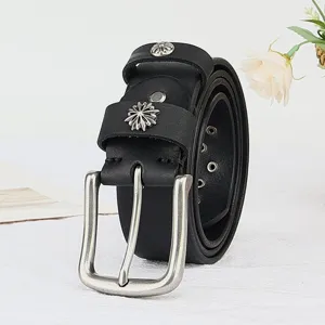 Close-up detail of black genuine leather belt with silver floral metal rivets and stylish buckle.