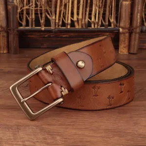 Men leather belt detail shot showing embossed palm trees pattern and bronze buckle craftsmanship.