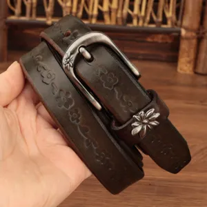 Primo piano di una cintura in pelle marrone con fiori goffrati e fibbia d'argento
