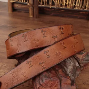 Detailed view of vintage brown leather belt with embossed palm tree pattern, high quality.