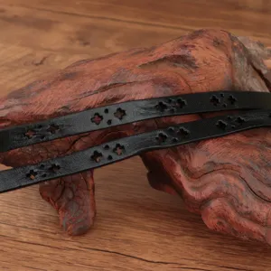 Close up of black leather belt featuring cutout cross pattern details for vintage style.