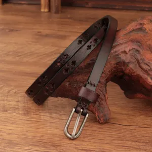 Detailed view of the dark brown genuine leather thin belt featuring vintage cutout floral patterns.