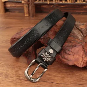 Dettaglio di una cintura vintage in pelle nera con eleganti motivi floreali