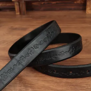 Primo piano dei complessi motivi floreali in rilievo su una cintura vintage in pelle nera