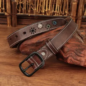 Close-up of retro brown leather belt with colorful star embroidery and white stitching
