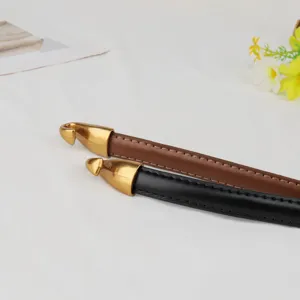 Detailed view of genuine leather belt straps with vintage metal hook ends in black and brown.