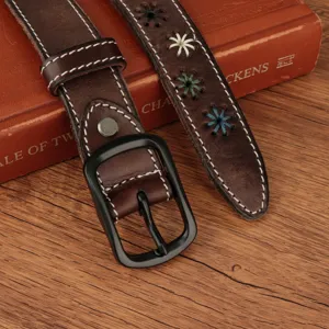 Close-up of a vintage brown leather belt with colorful floral embroidery and matte black buckle