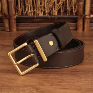 Detail of a brown top layer cowhide leather belt with a classic square brass buckle.