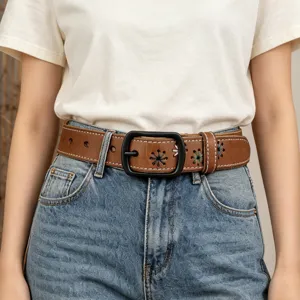 Close-up of stylish brown leather belt featuring floral embroidery and black buckle